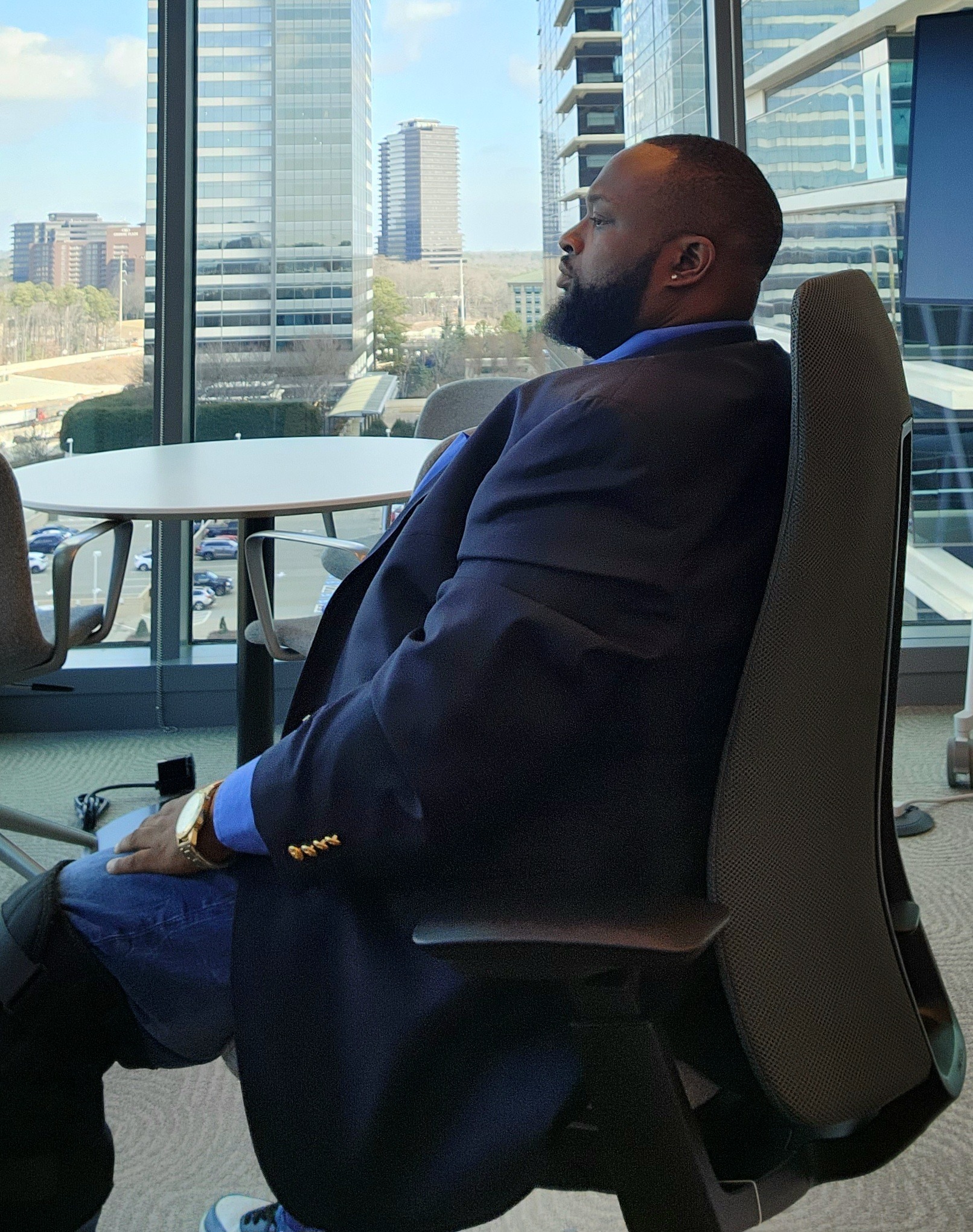 Ken Anderson seated beside a window overlooking the city